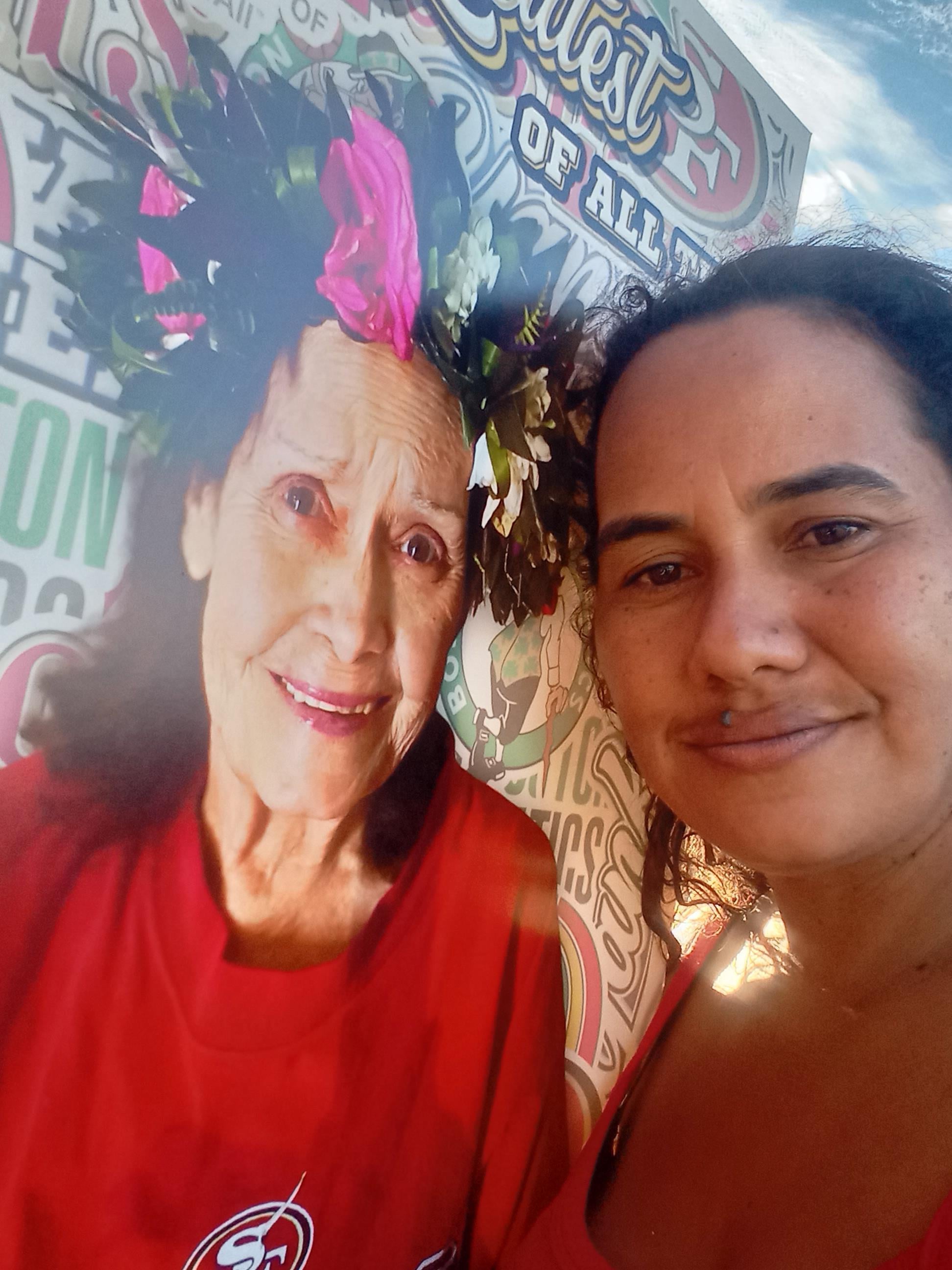 A woman taking a selfie with a woman with a flower crown