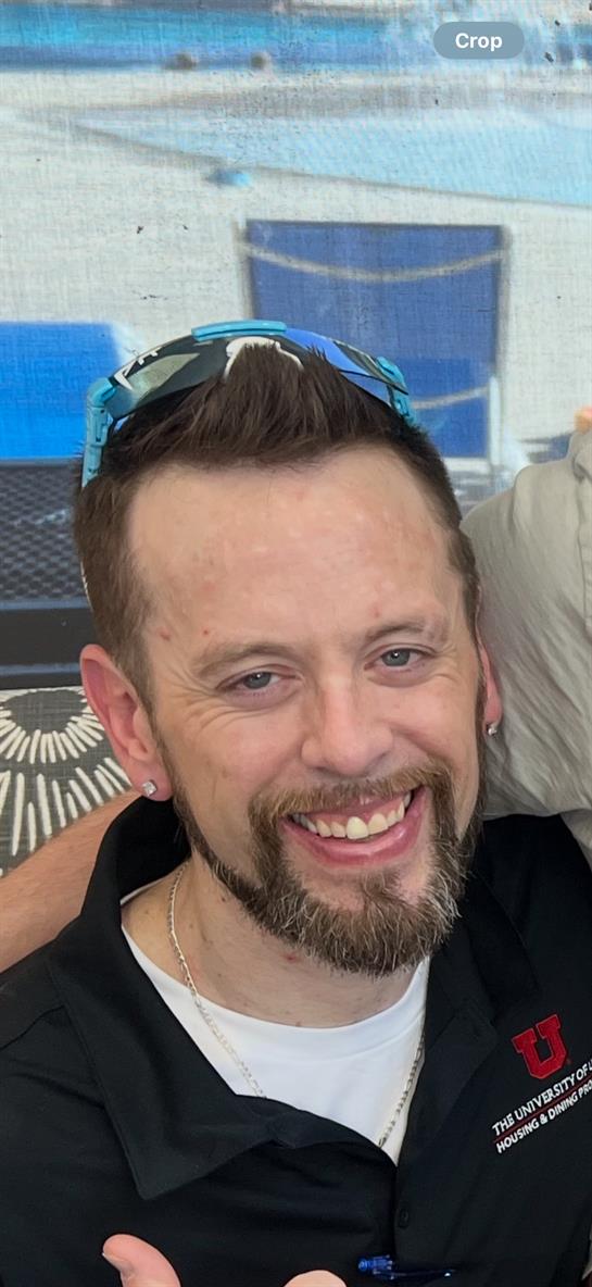 A man smiling with sunglasses on his head