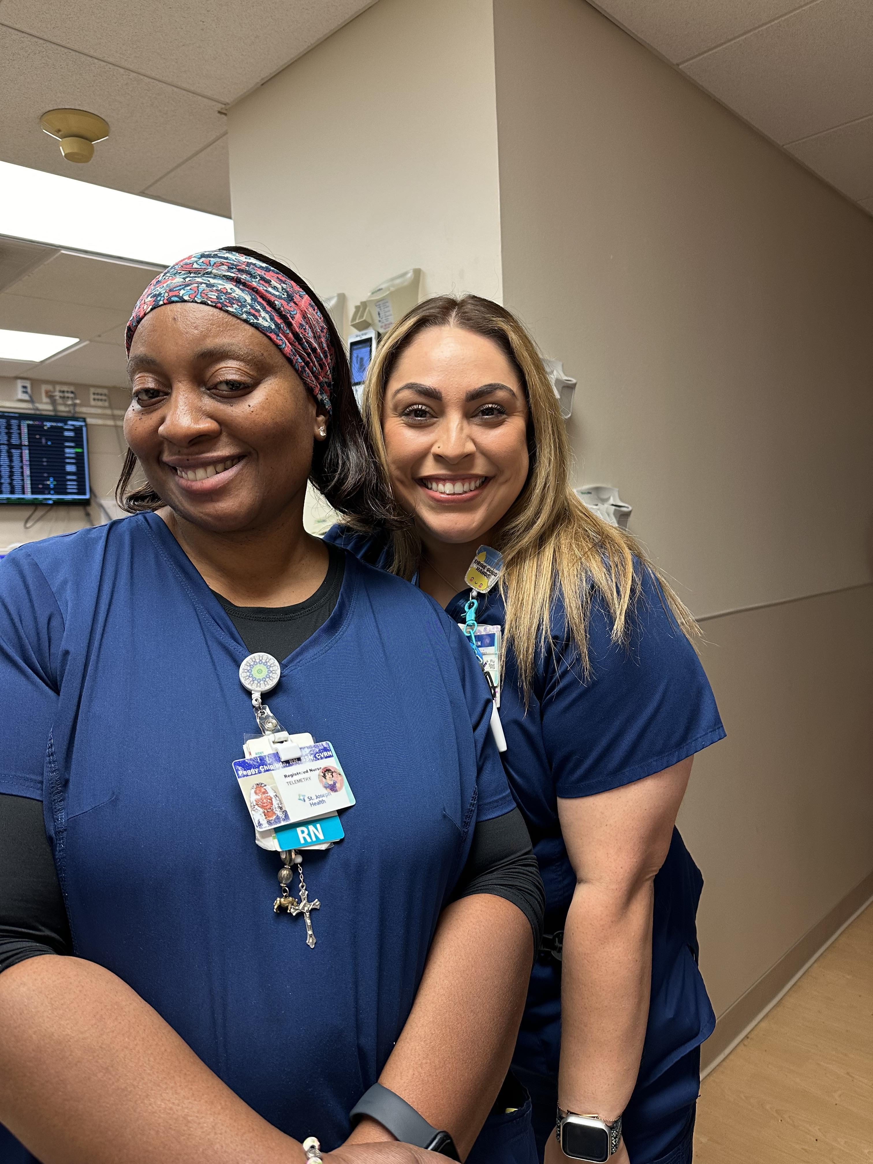 A couple of women in scrubs smiling