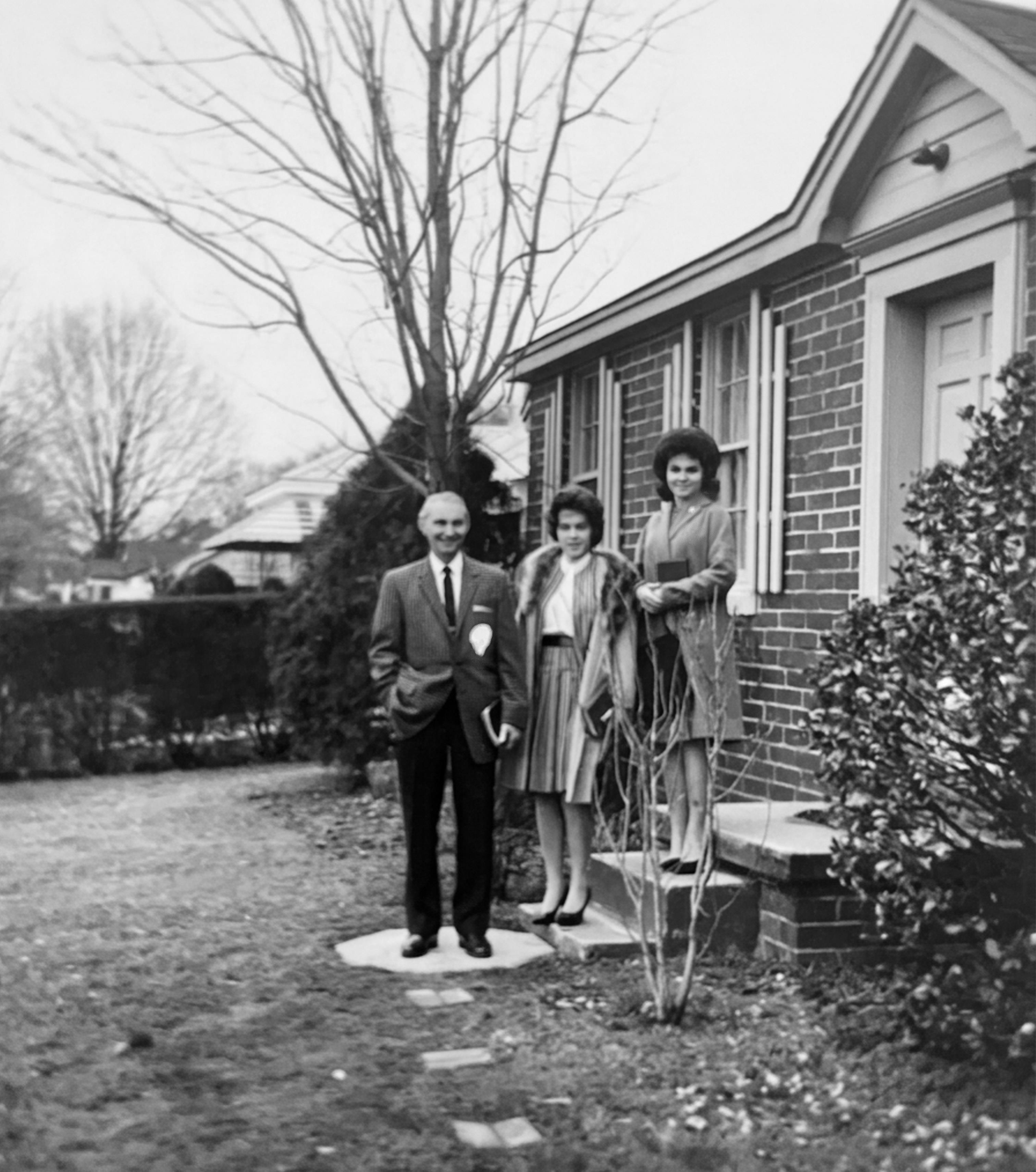 A group of people standing outside a house