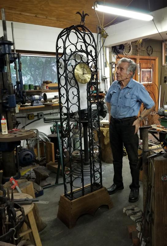 A man standing next to a large clock