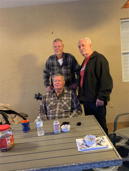 A group of men standing around a table