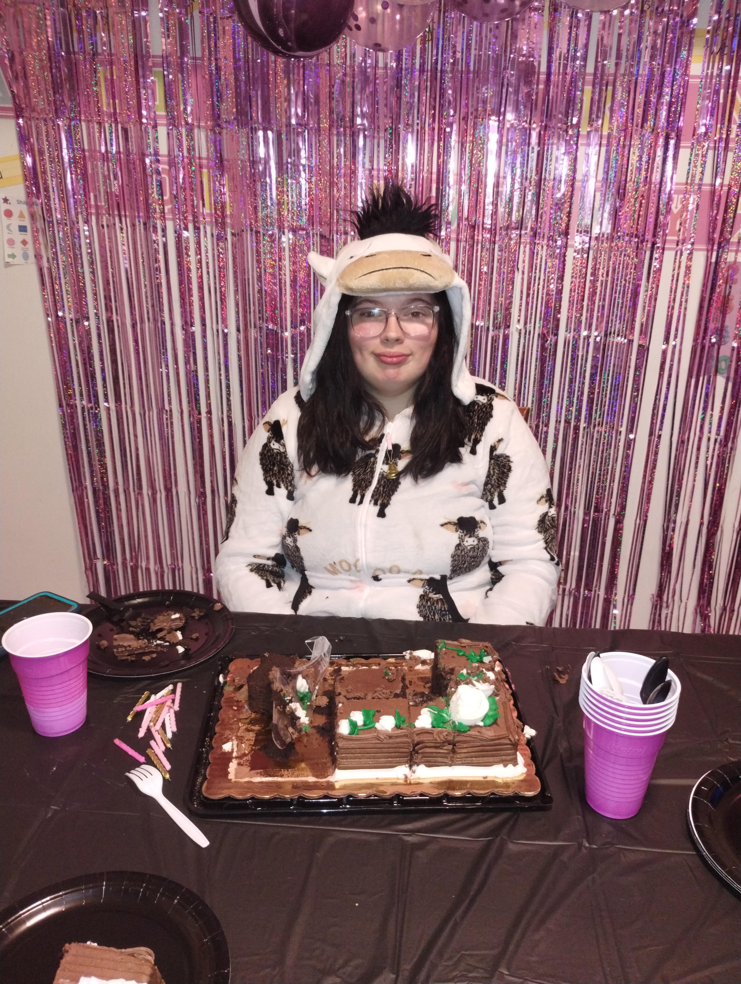 A woman sitting at a table with a cake