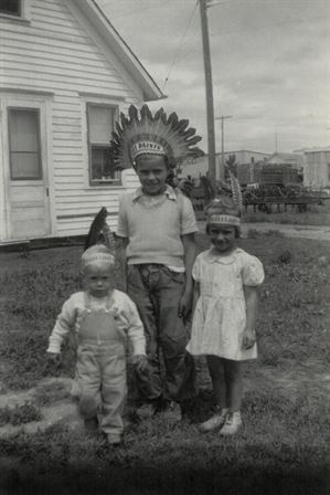 A group of children standing in front of a house