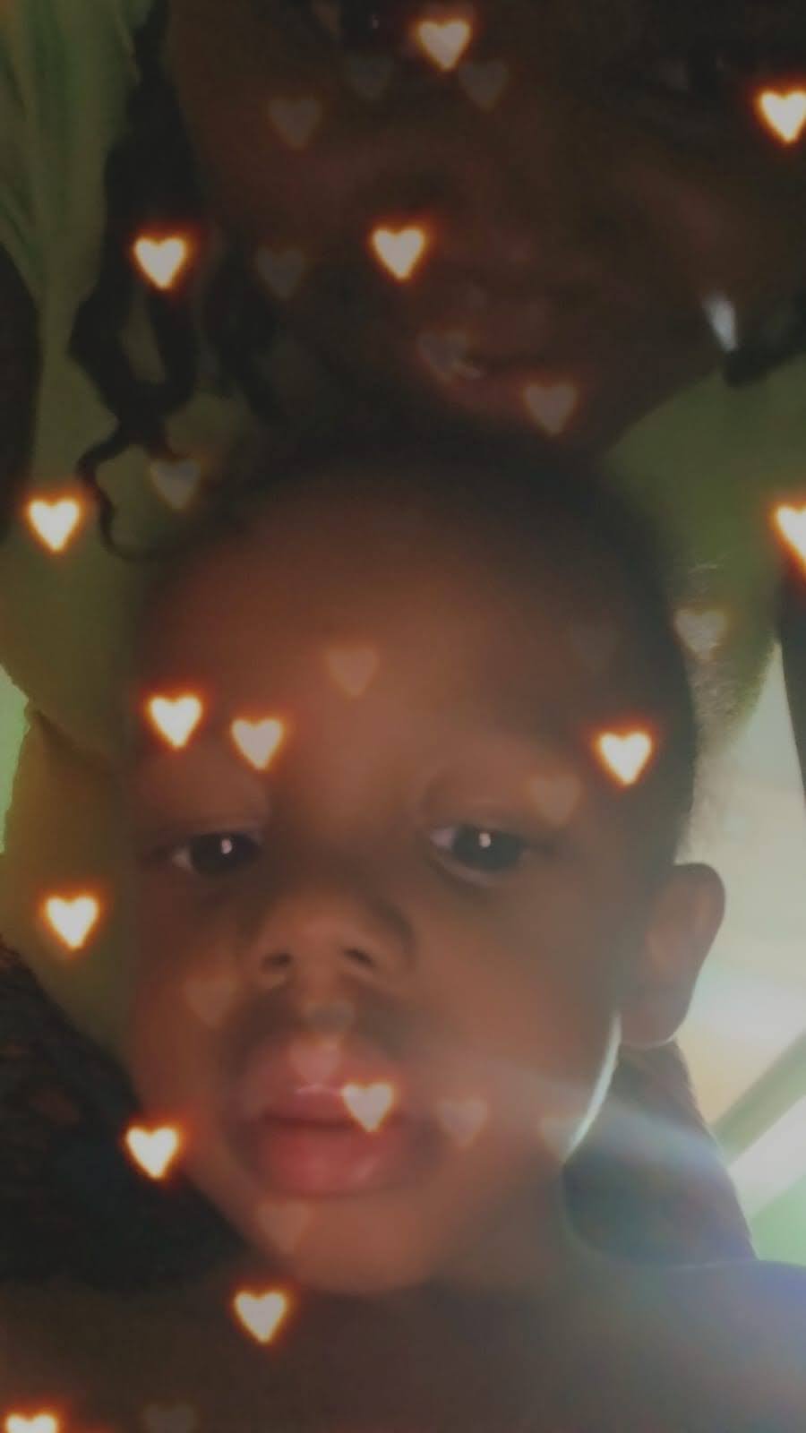 A child lying down with hearts around them
