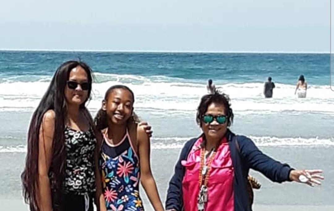 A group of people posing for a picture on a beach