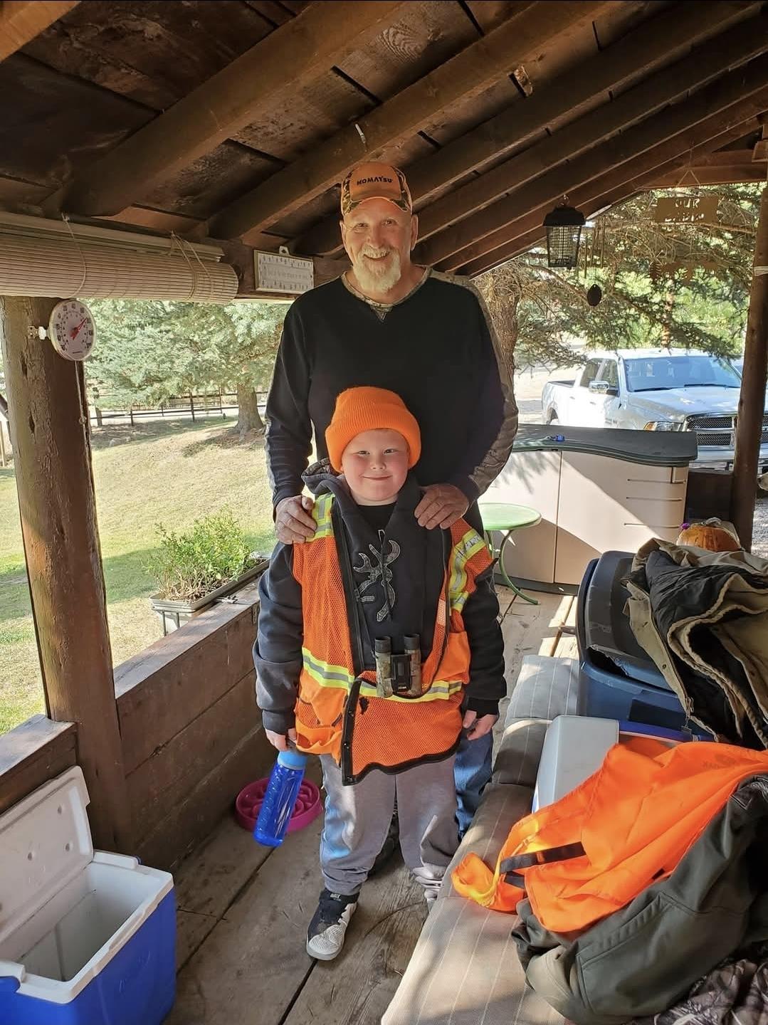 A man and boy standing under a covered porch