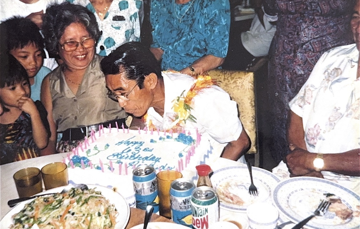 A man blowing out candles on his birthday cake