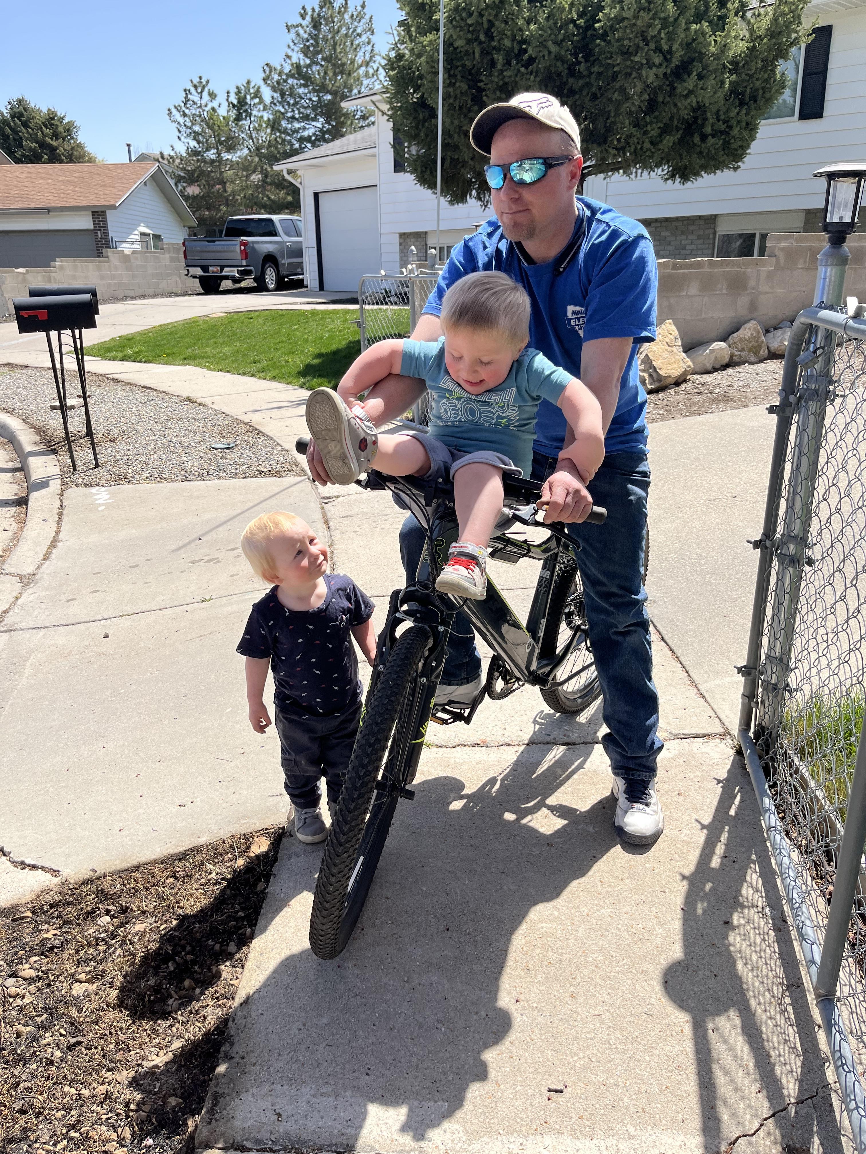 A man holding a child on a bicycle