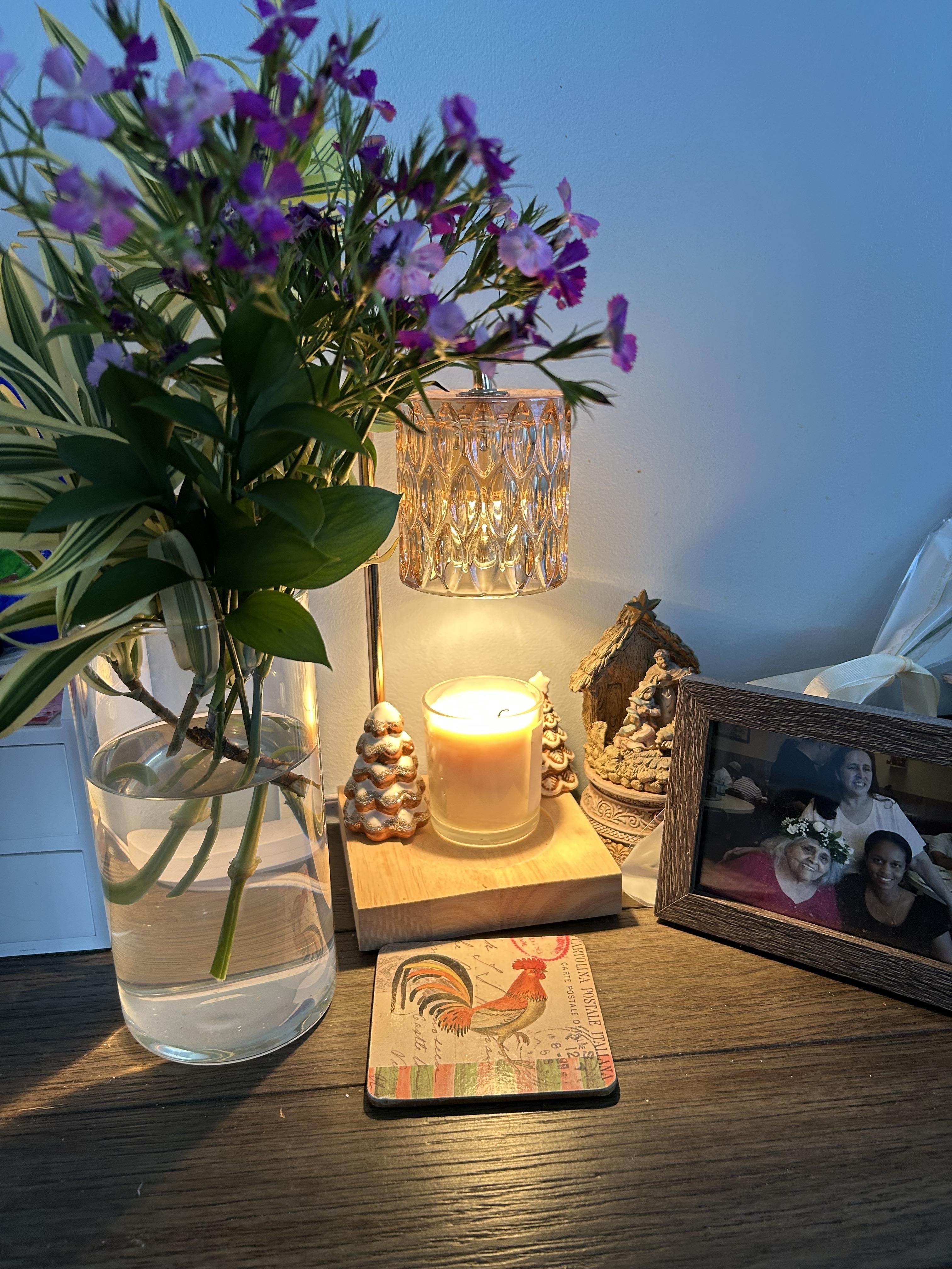 A vase of flowers and a candle on a table