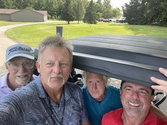 A group of men in a golf cart