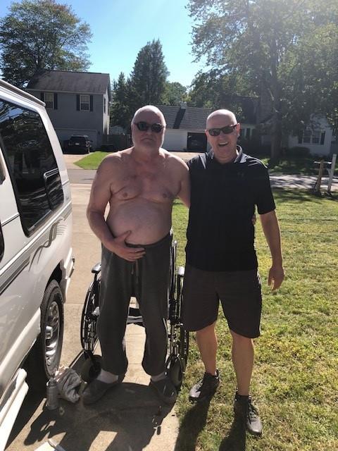 A man in a wheelchair next to a man in a wheelchair