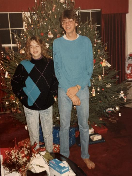 Two people standing in front of a christmas tree