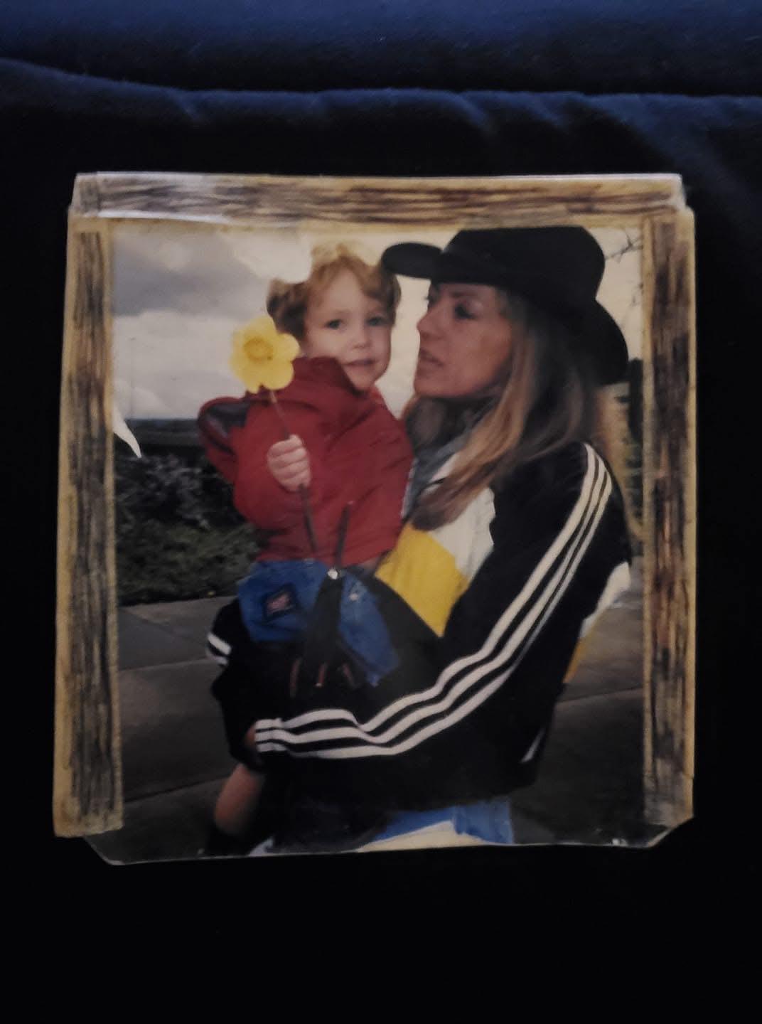 A woman enjoys time with a young child outside. They share a smile and a moment together.