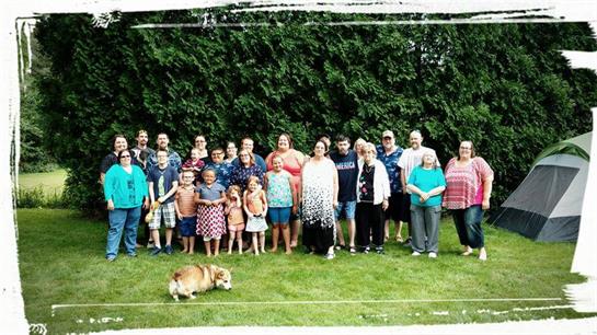 A group of people standing in a grassy area