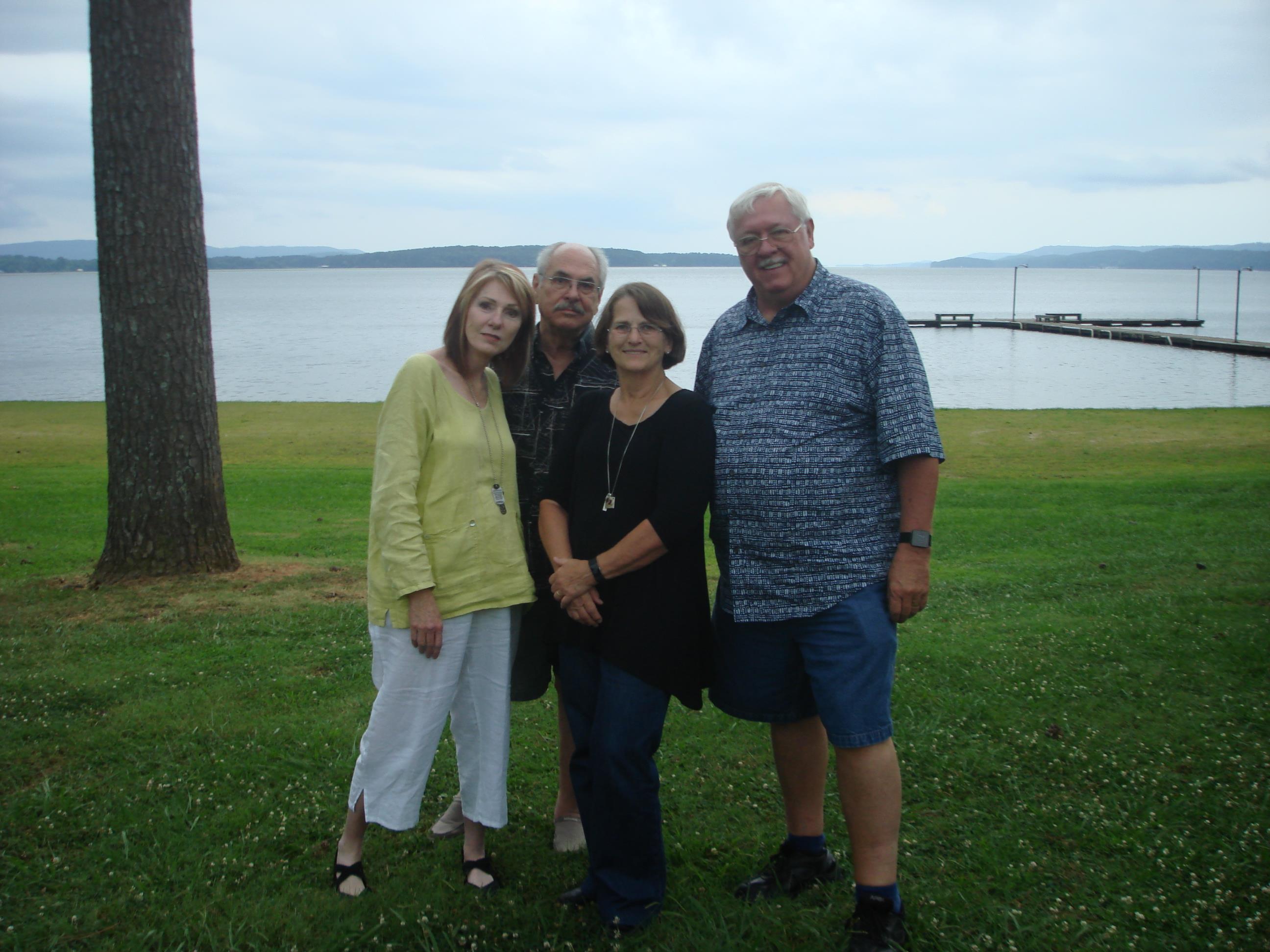 A group of people standing in a grassy area