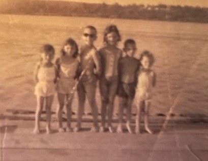 A group of children standing in front of water