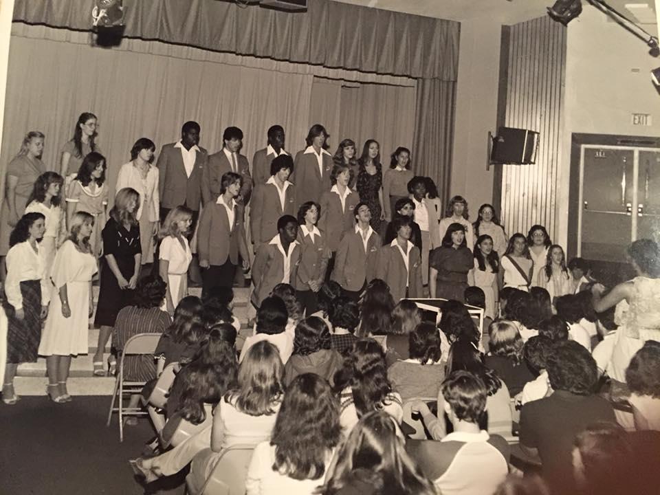 A group of people standing in front of a large crowd