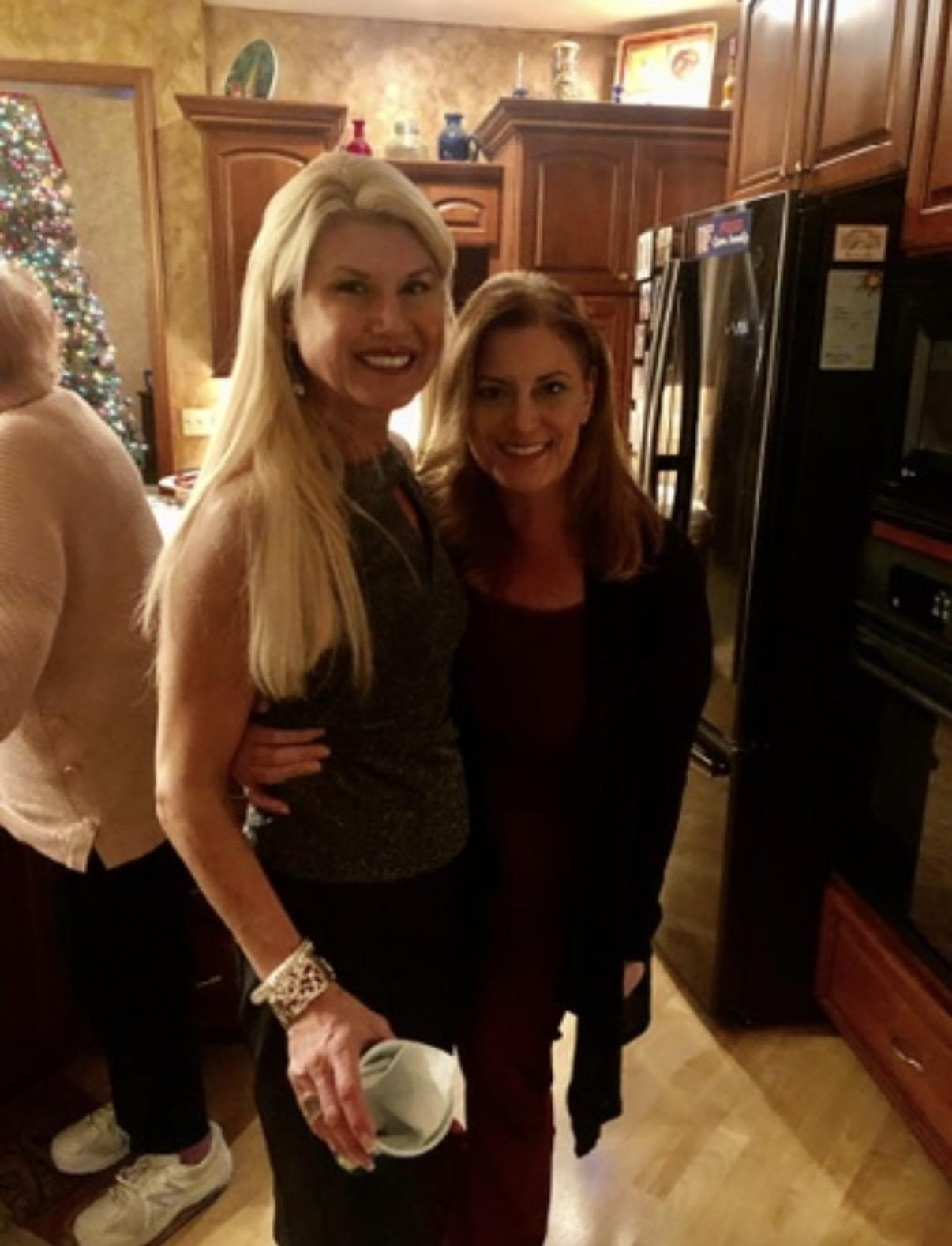 A couple of women standing in a kitchen