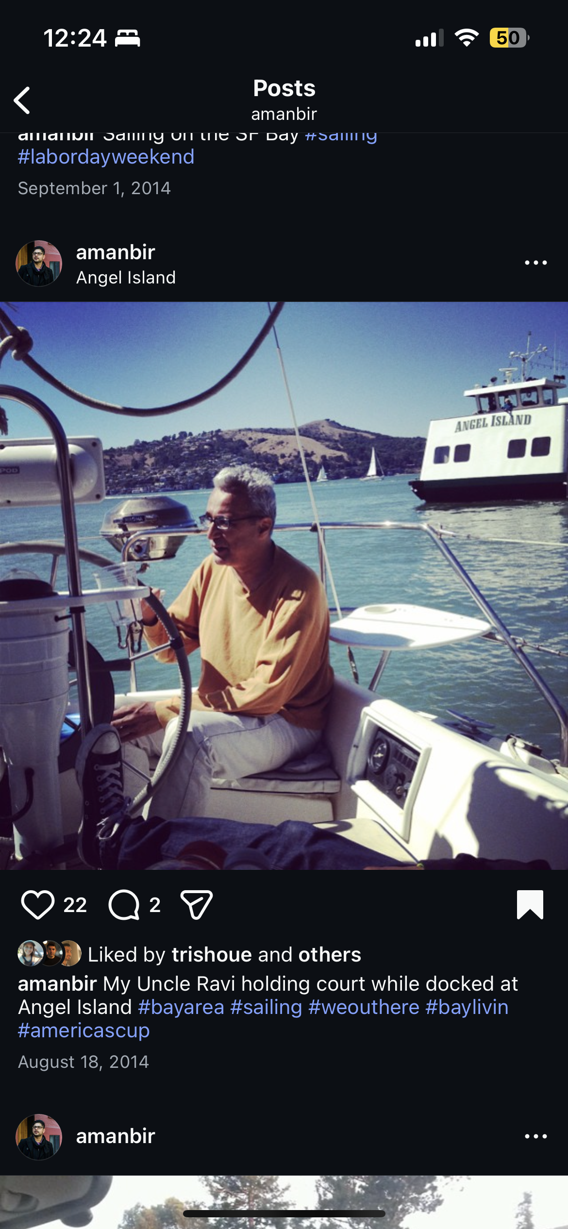 A person is on a small boat near Angel Island. The water is clear and calm, and a ferry is visible.