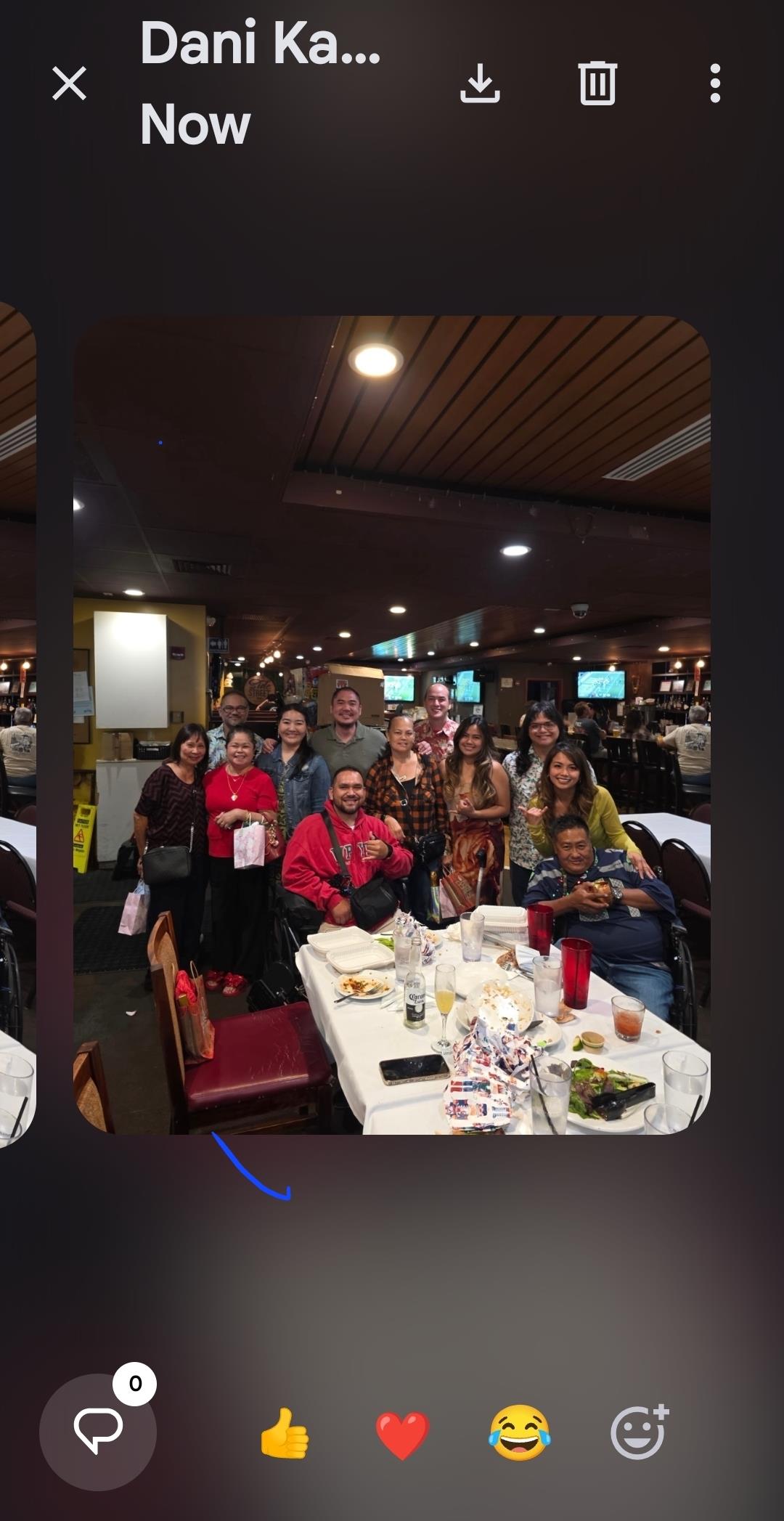 People gather around tables at a restaurant for a dinner celebration with food and drinks.