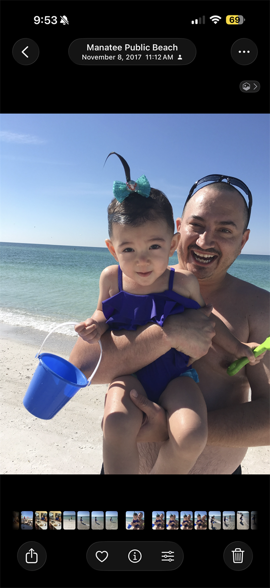 A man holding a baby on a beach