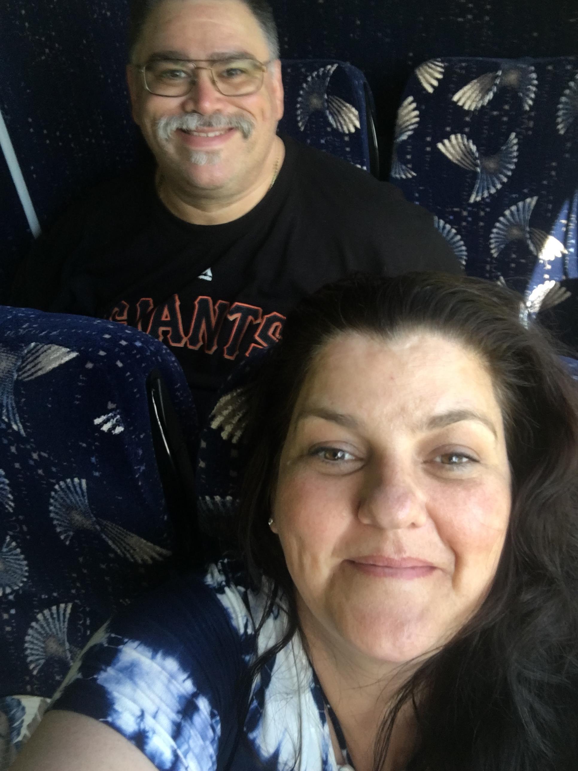 Two people share a moment on the bus as they smile and enjoy the trip together.