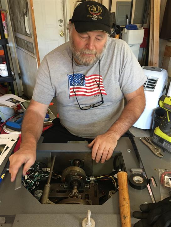 A man in a hat working on a machine