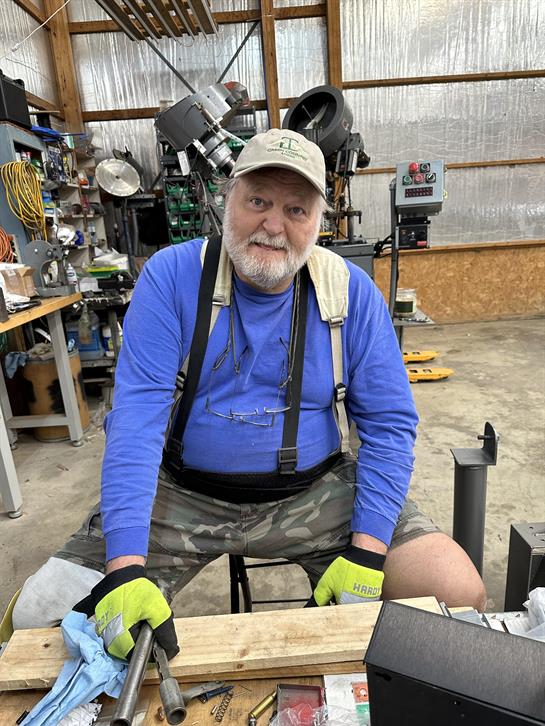 A man sitting on a stool in a workshop