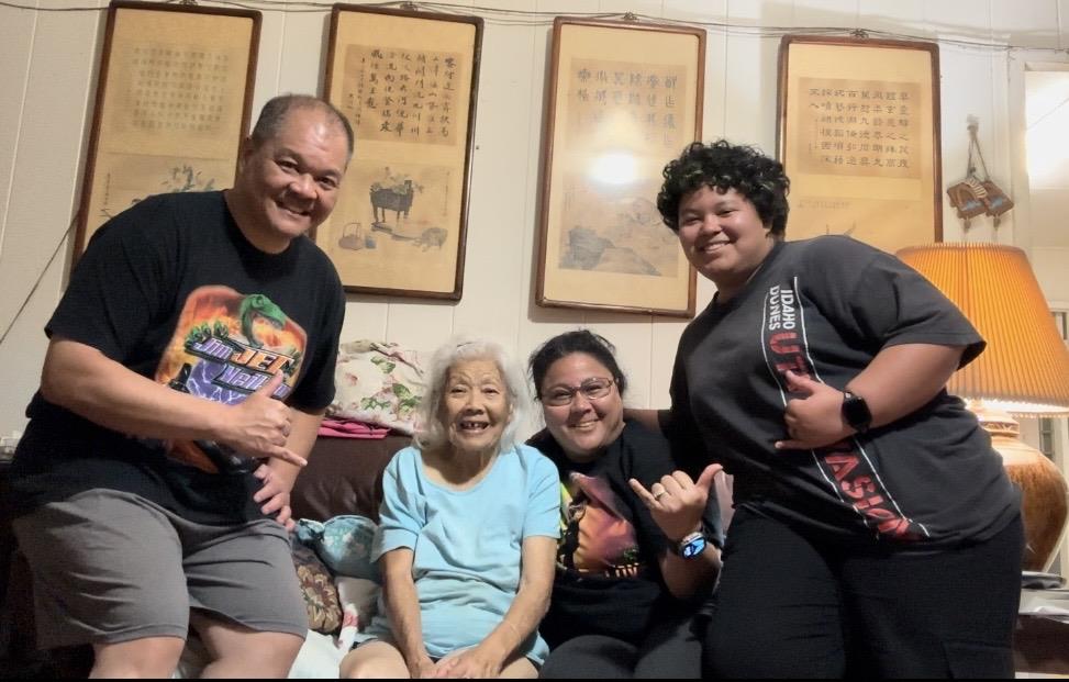 Four family members stand together with smiles in a cozy living room.