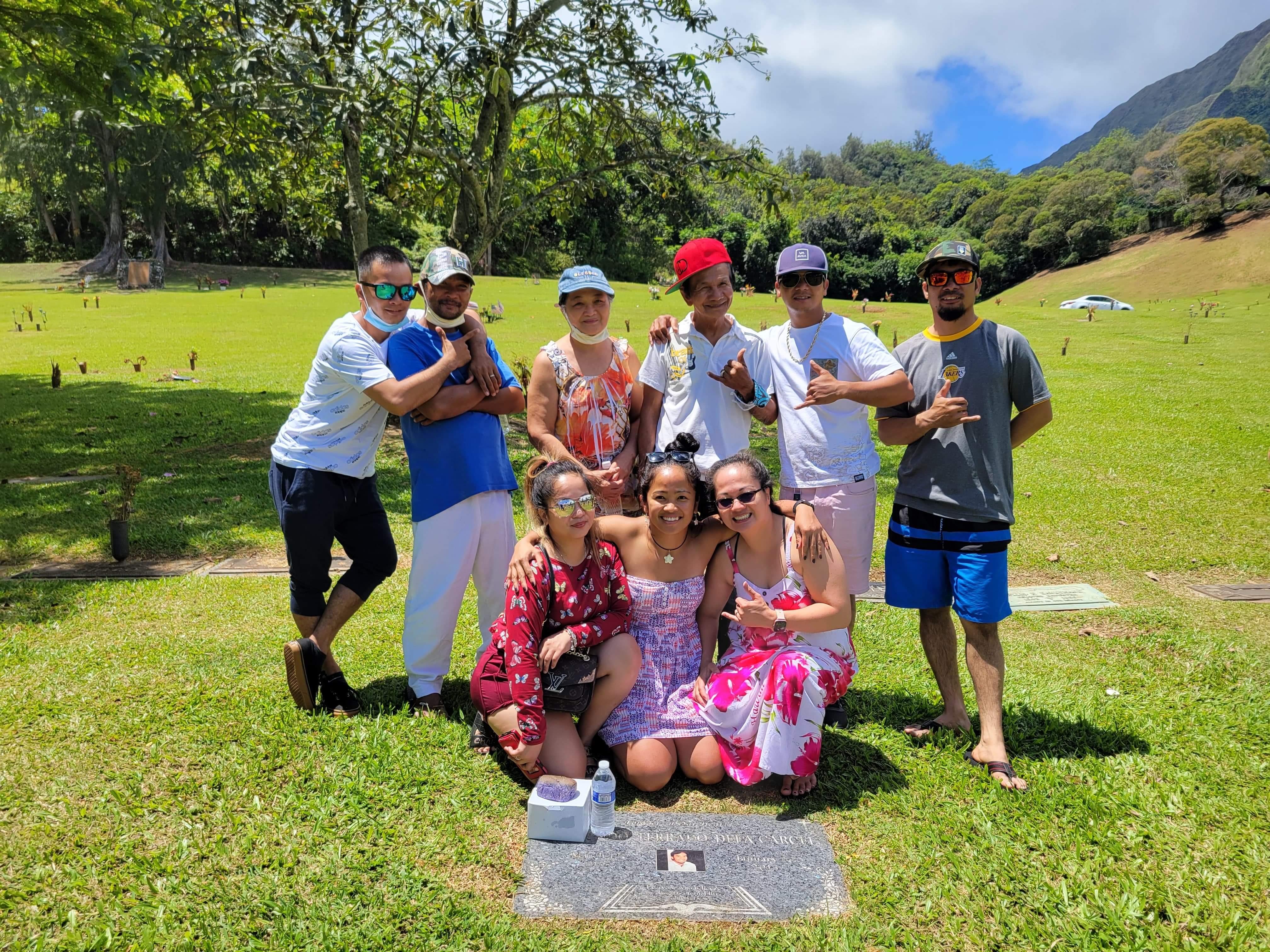 A group of friends and family gather on the grass for a fun day outside in the sun.