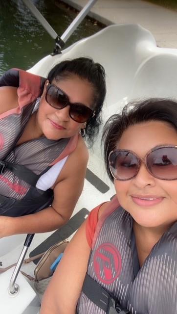 Two friends smile and take a selfie while sitting together, ready for a beach adventure.