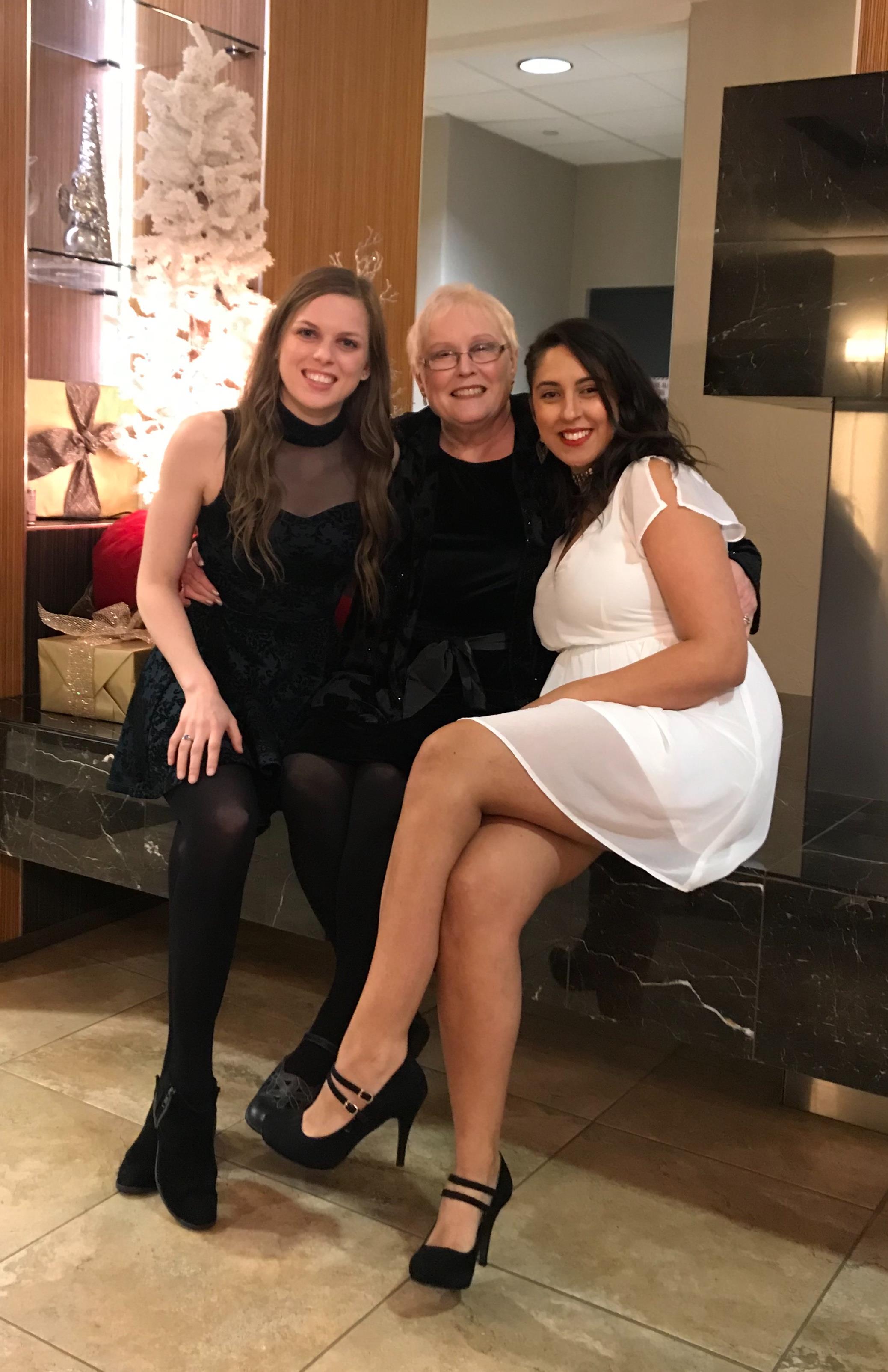 Three women are sitting closely together and smiling while enjoying time together.