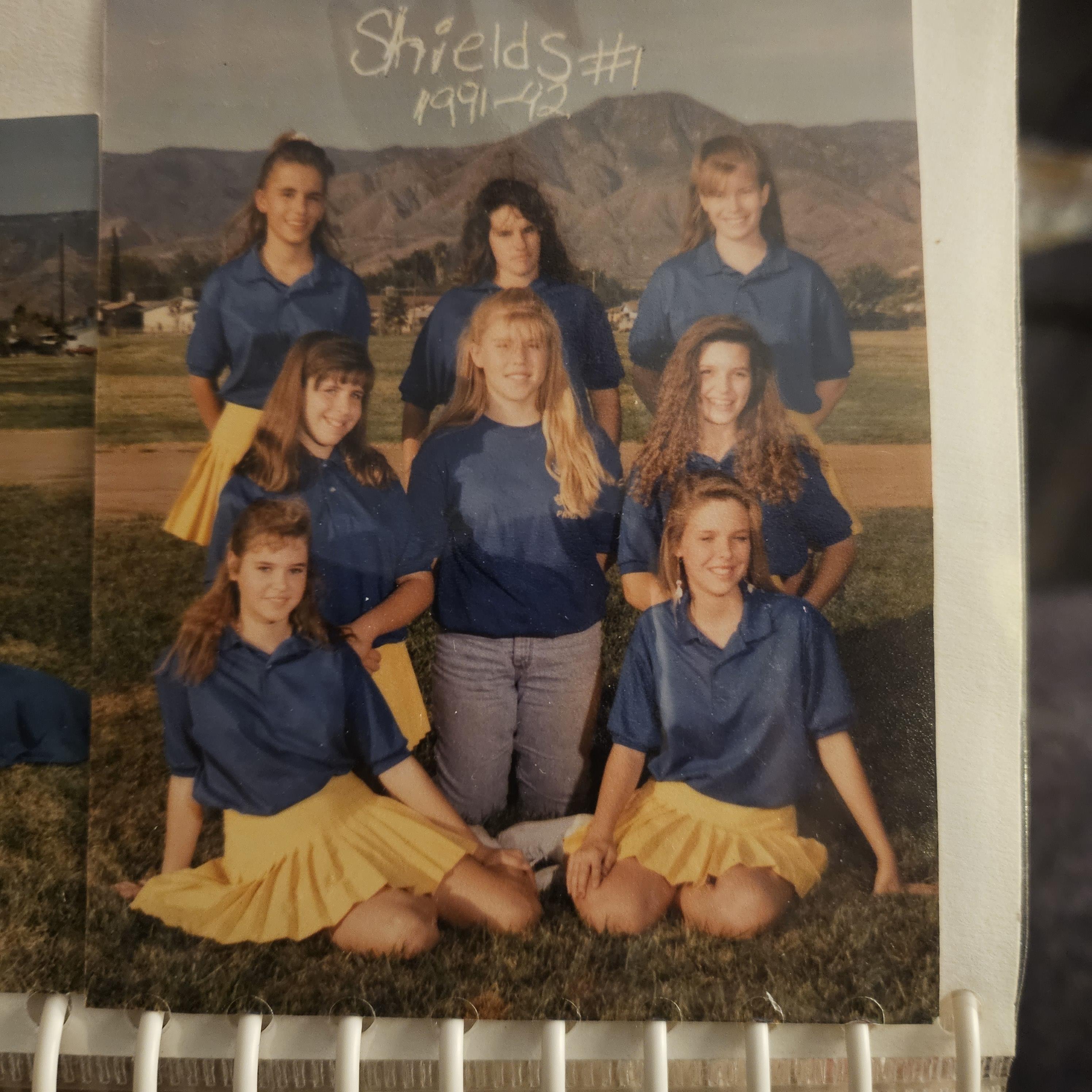 A group of girls in blue shirts and yellow skirts