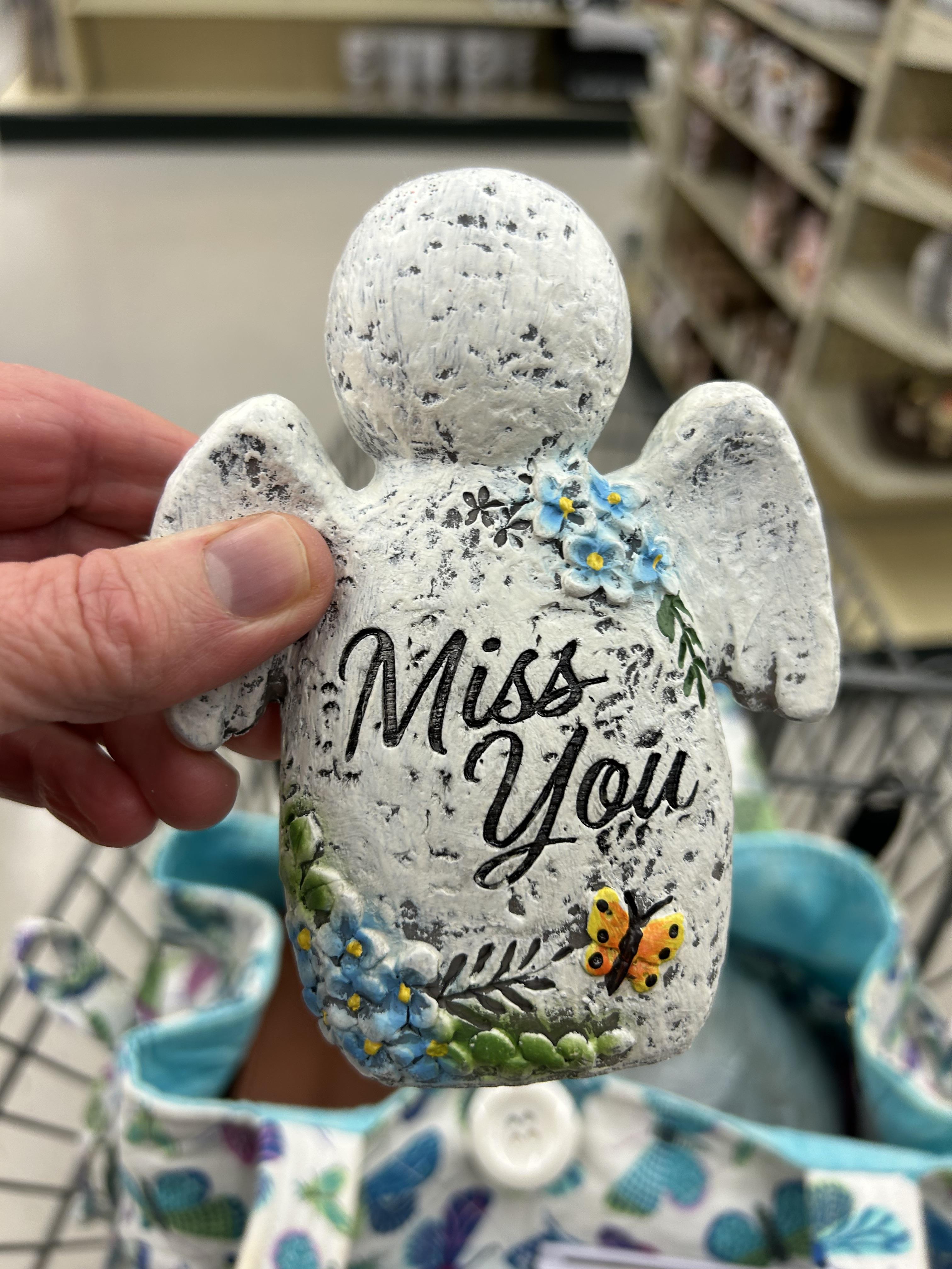 A hand holding a stone angel