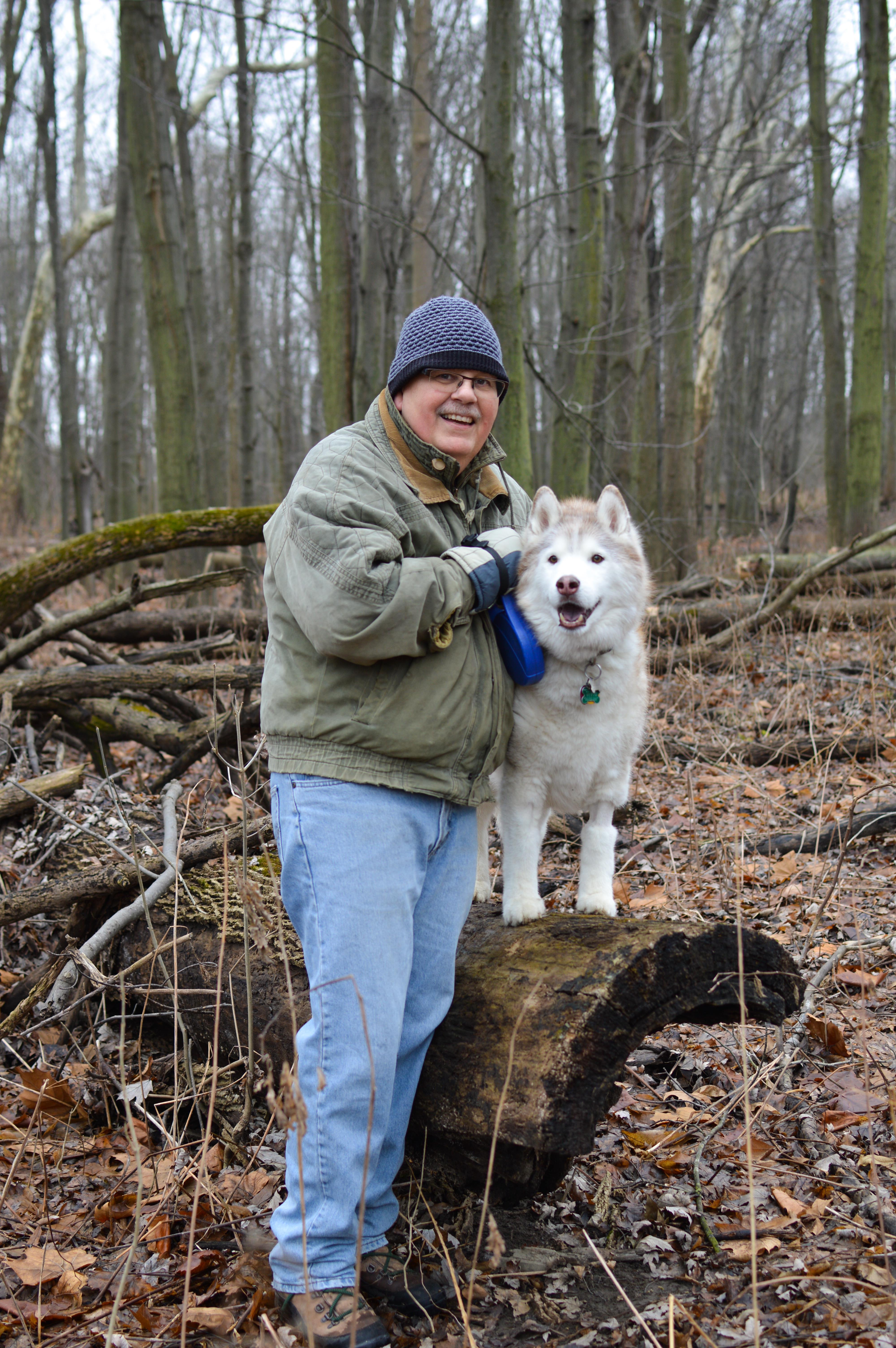 A man standing on a log with a dog
