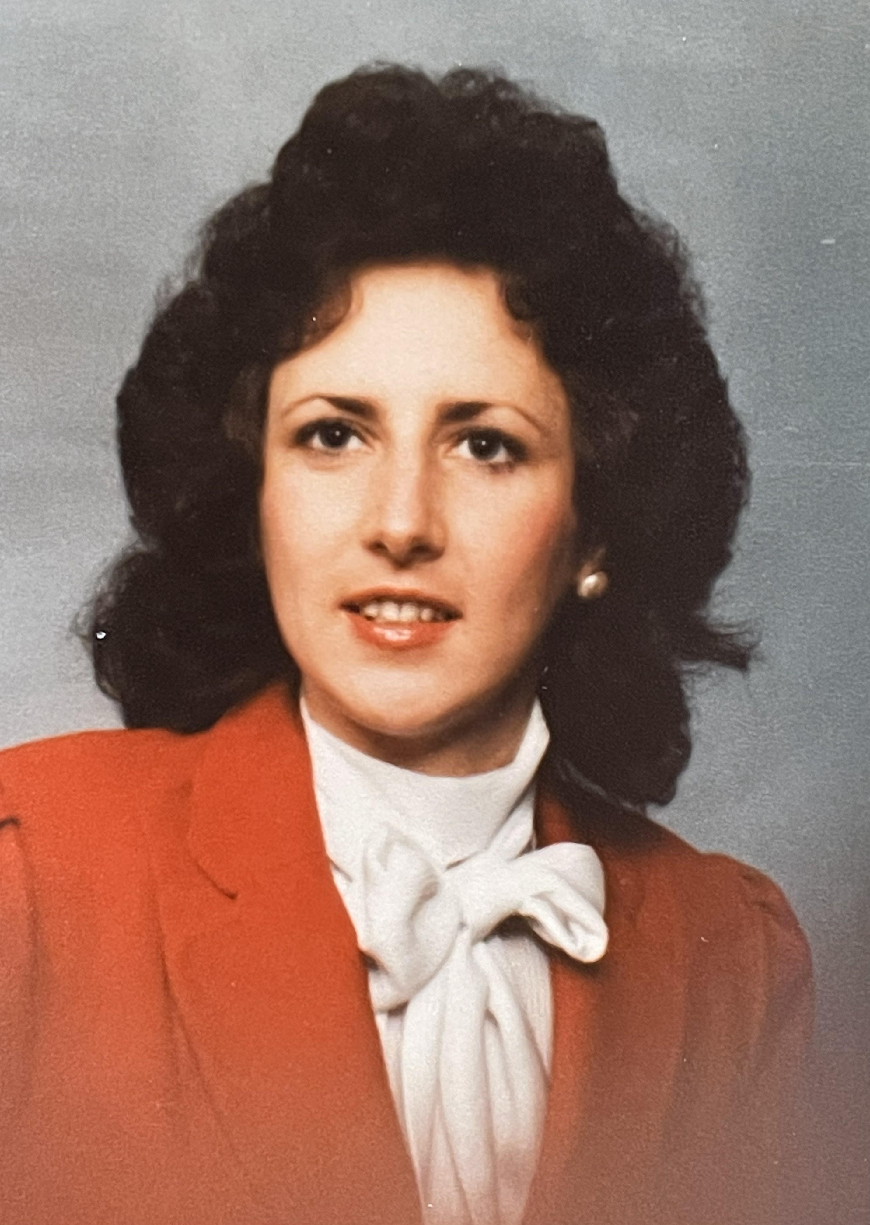 A woman with curly hair wearing a red jacket
