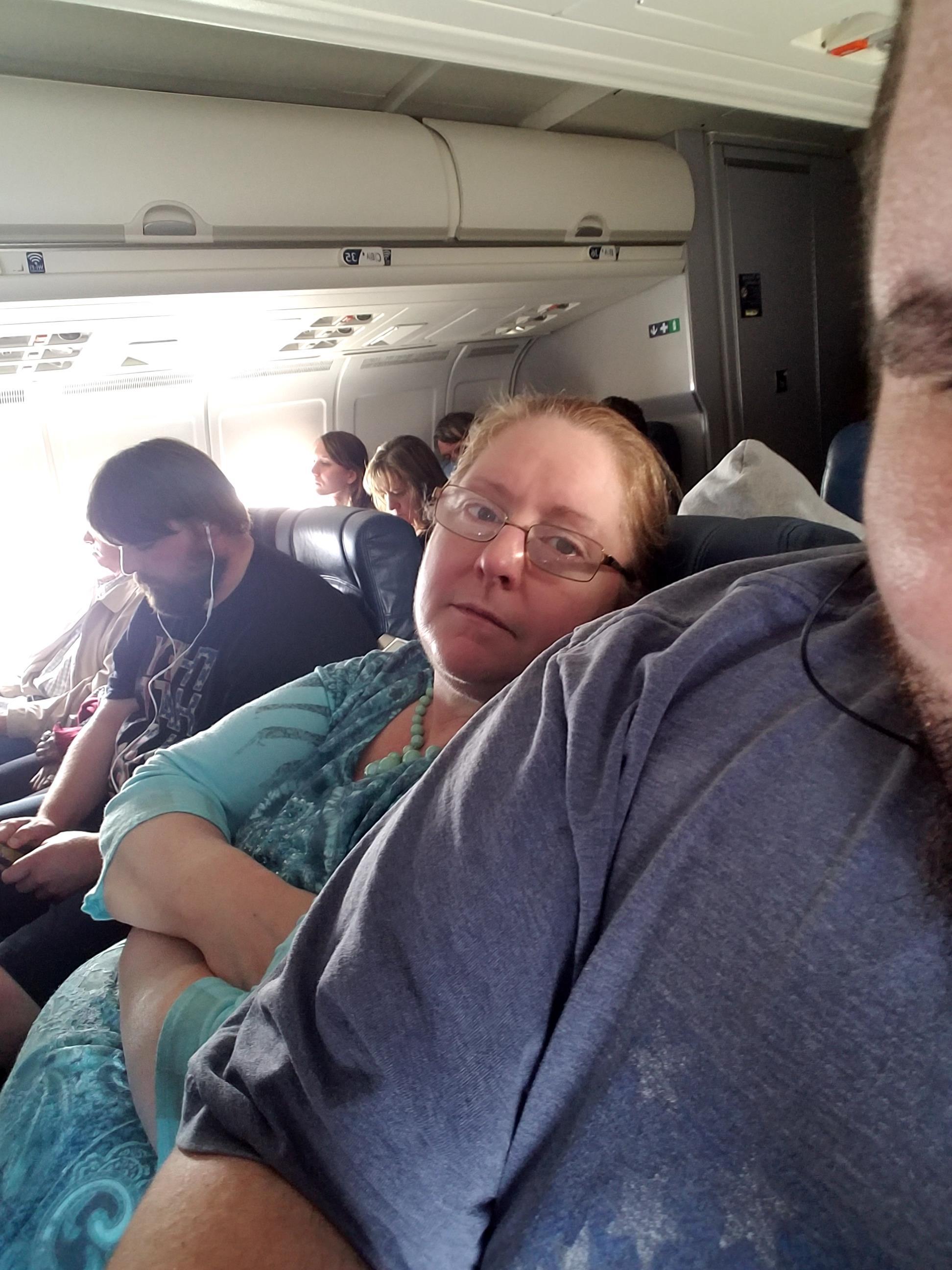A woman sitting on a seat in an airplane