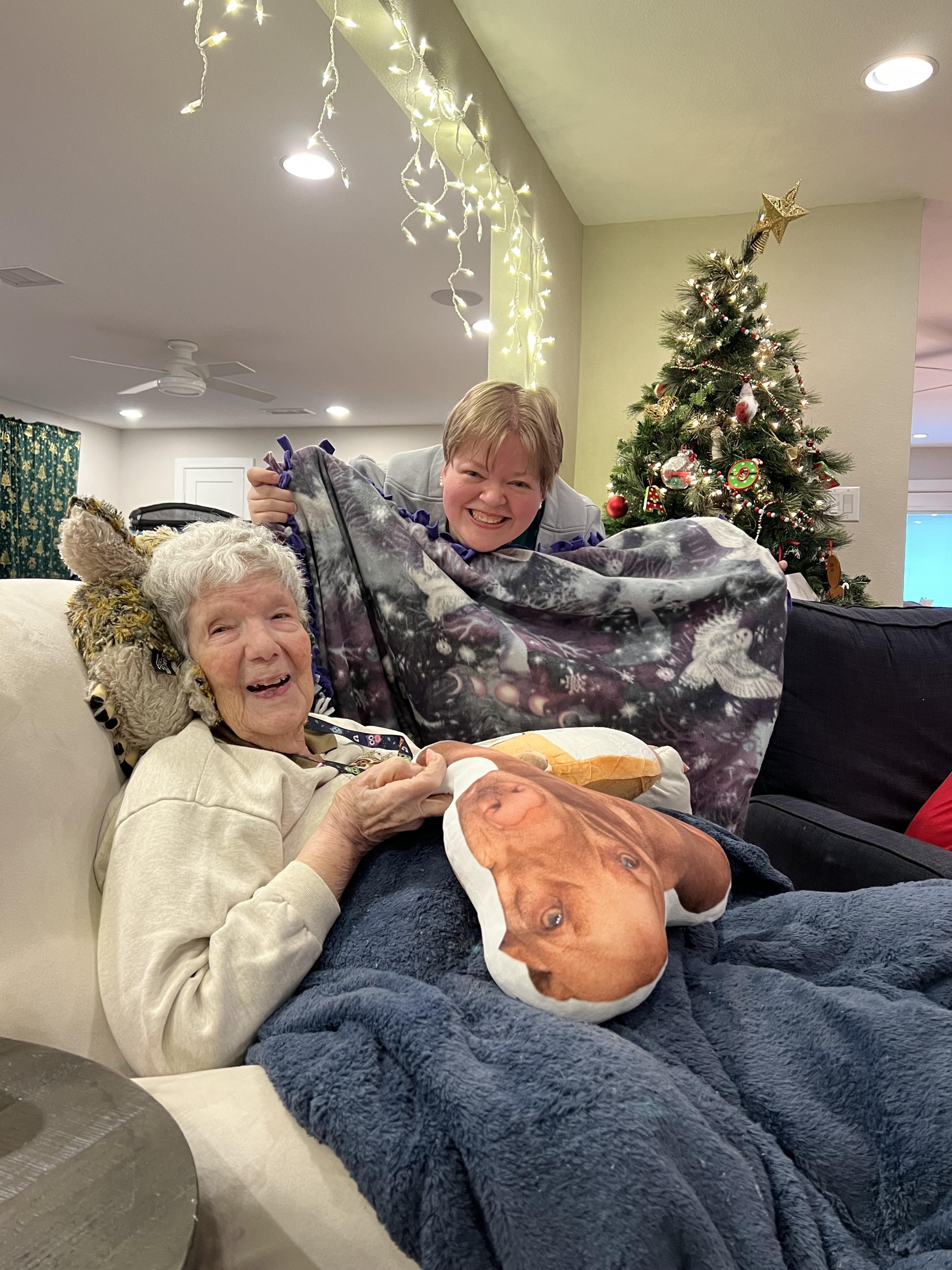 Two family members enjoy time together on a couch during the holiday season.
