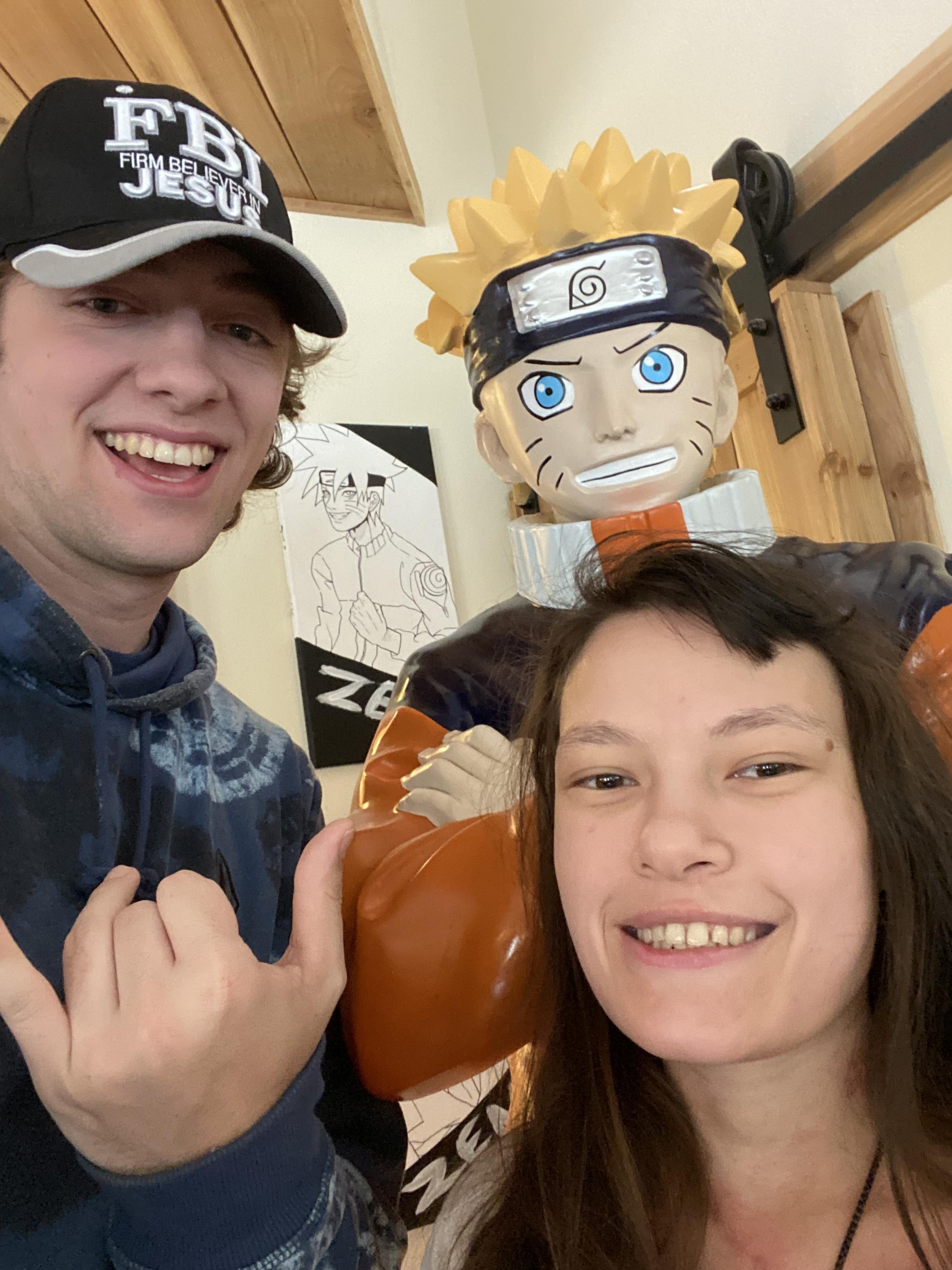 A man and woman posing with a statue