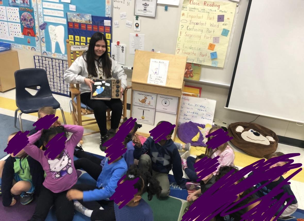 A woman in a classroom with a group of children