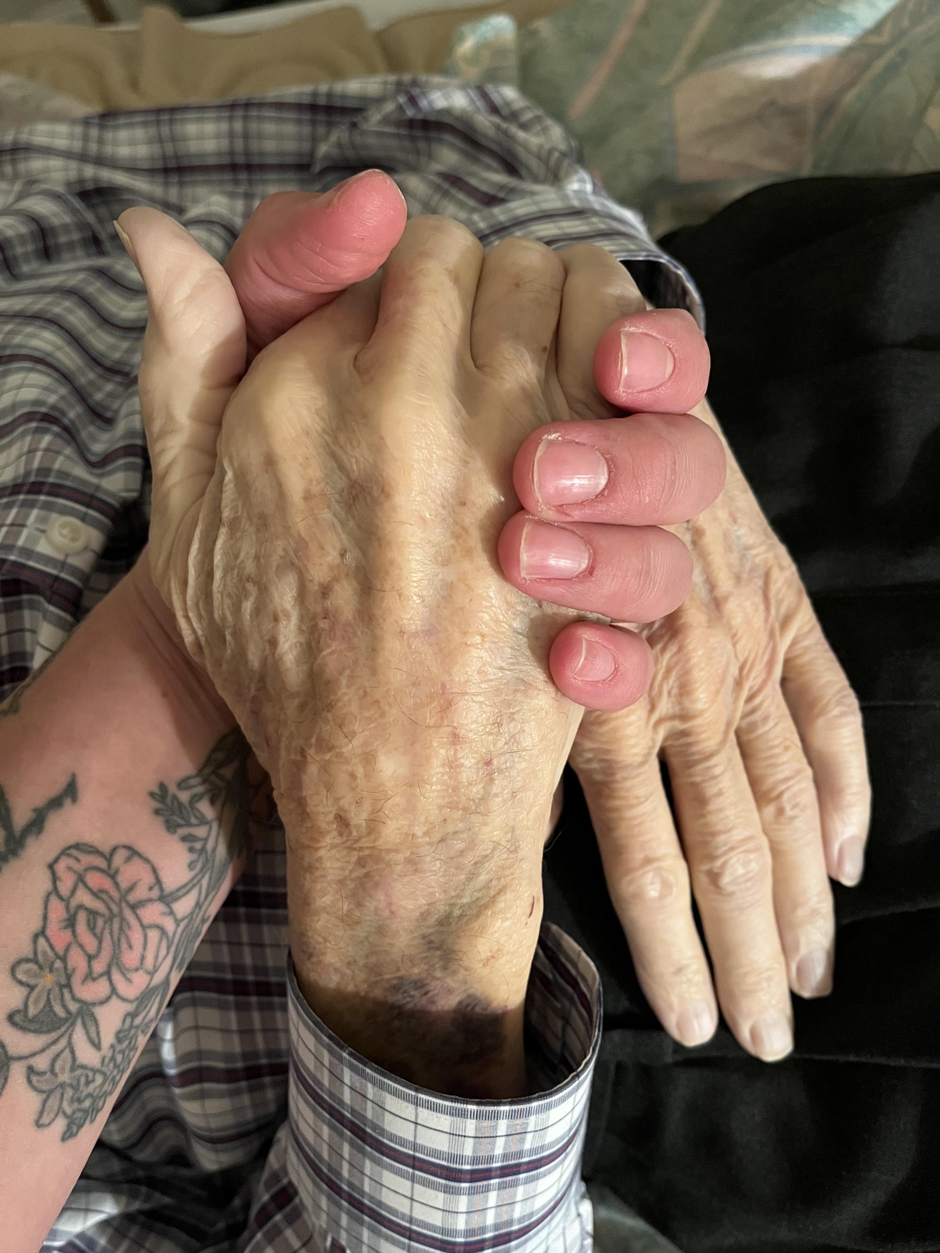 A person holding hands with tattoos