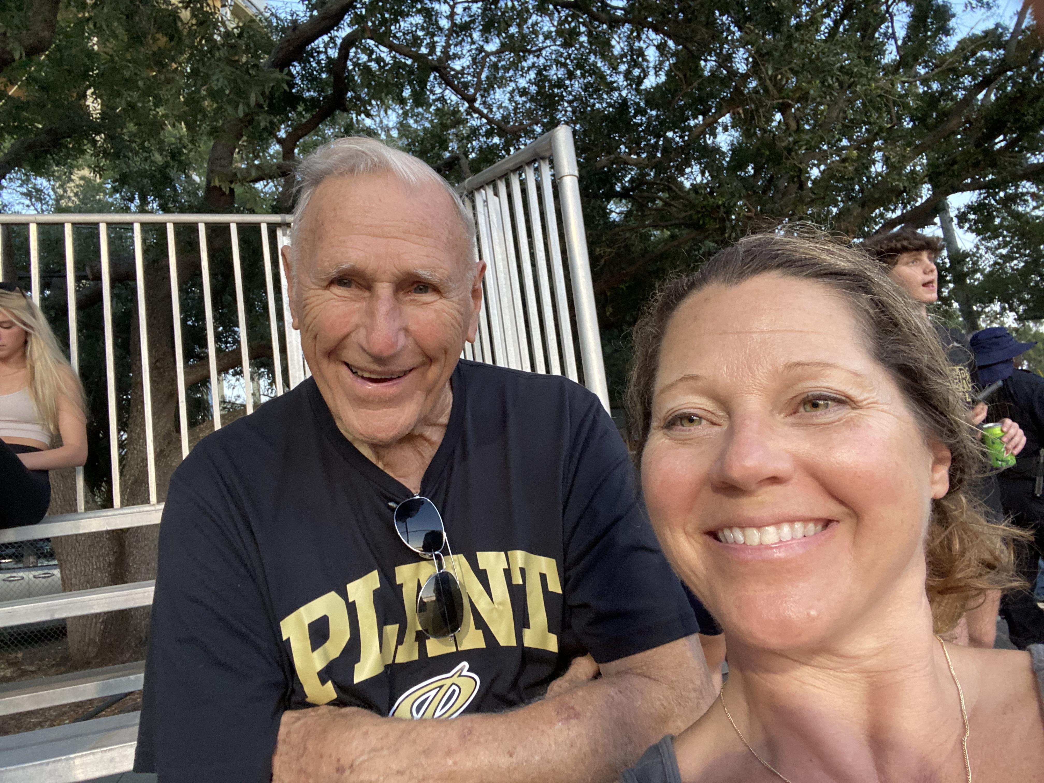 Two people enjoy a moment together in a park, sharing smiles and laughter during an event.