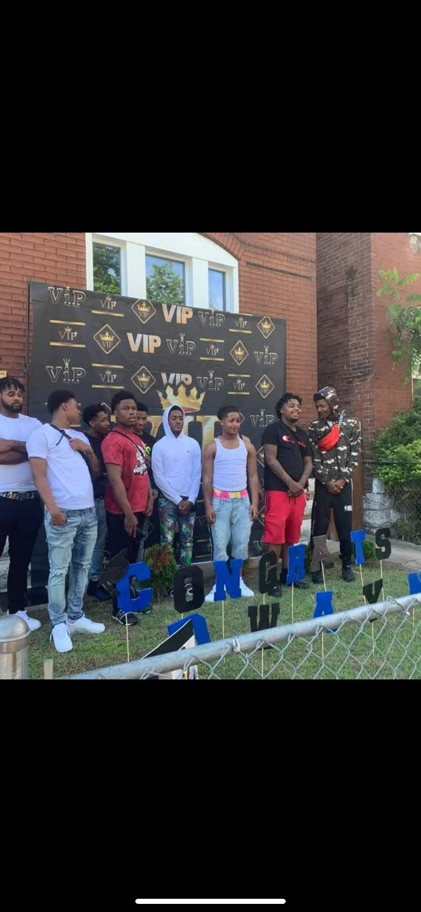 A group of people standing in front of a sign