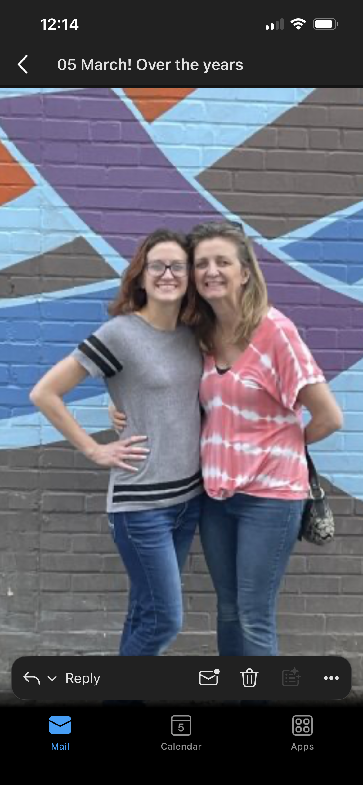 Two women standing in front of a wall