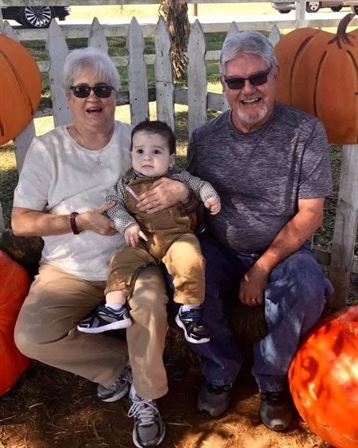A man and woman sitting on a bench with a baby