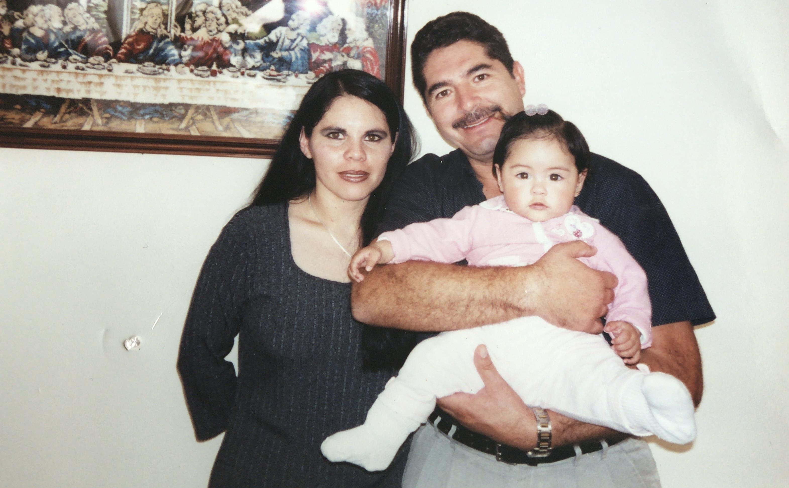 A man and woman holding a baby