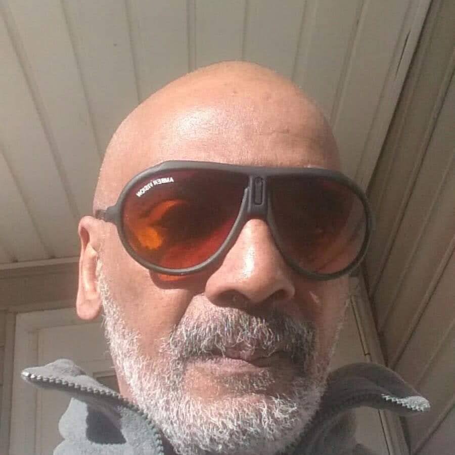 A man wearing sunglasses taking a selfie