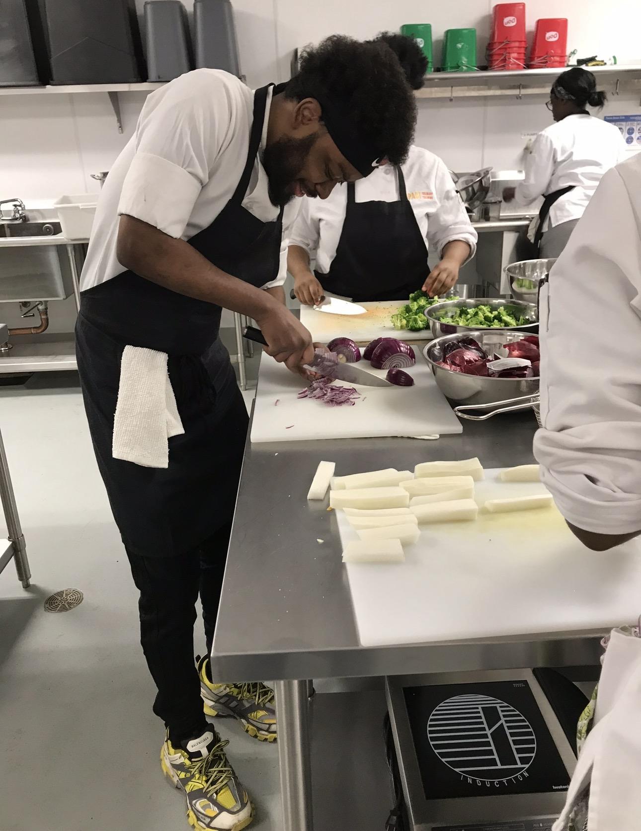 A man cutting onions in a kitchen