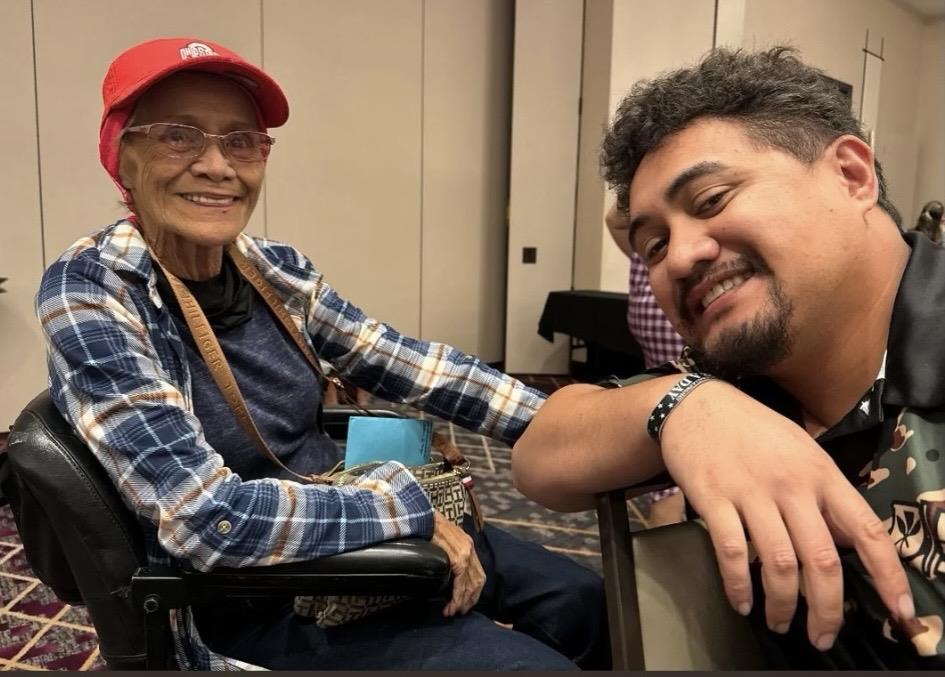 A man and woman sitting in a wheelchair